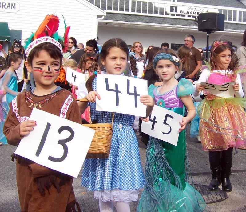 Pocahontas, Dorothy, Ariel and a fairy show judges their numbers during the costume contest at the Plumb Corner Halloween celebration. BY MATTHEW BERNAT